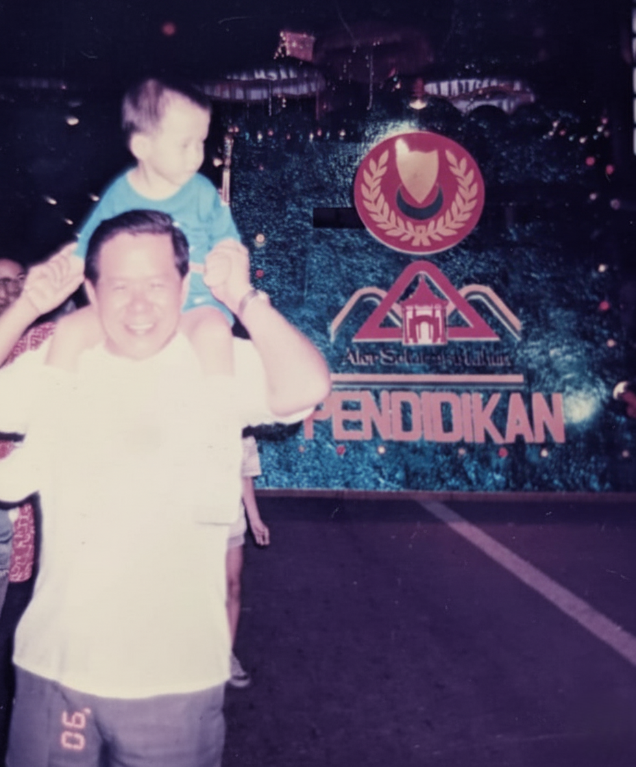 Tim Cheah as a child on his uncle's shoulders at an education event